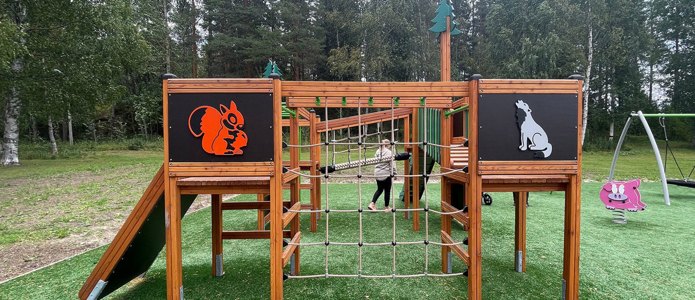 Lekställning med vildmarksmotiv, grönt gräs och parkmiljö.