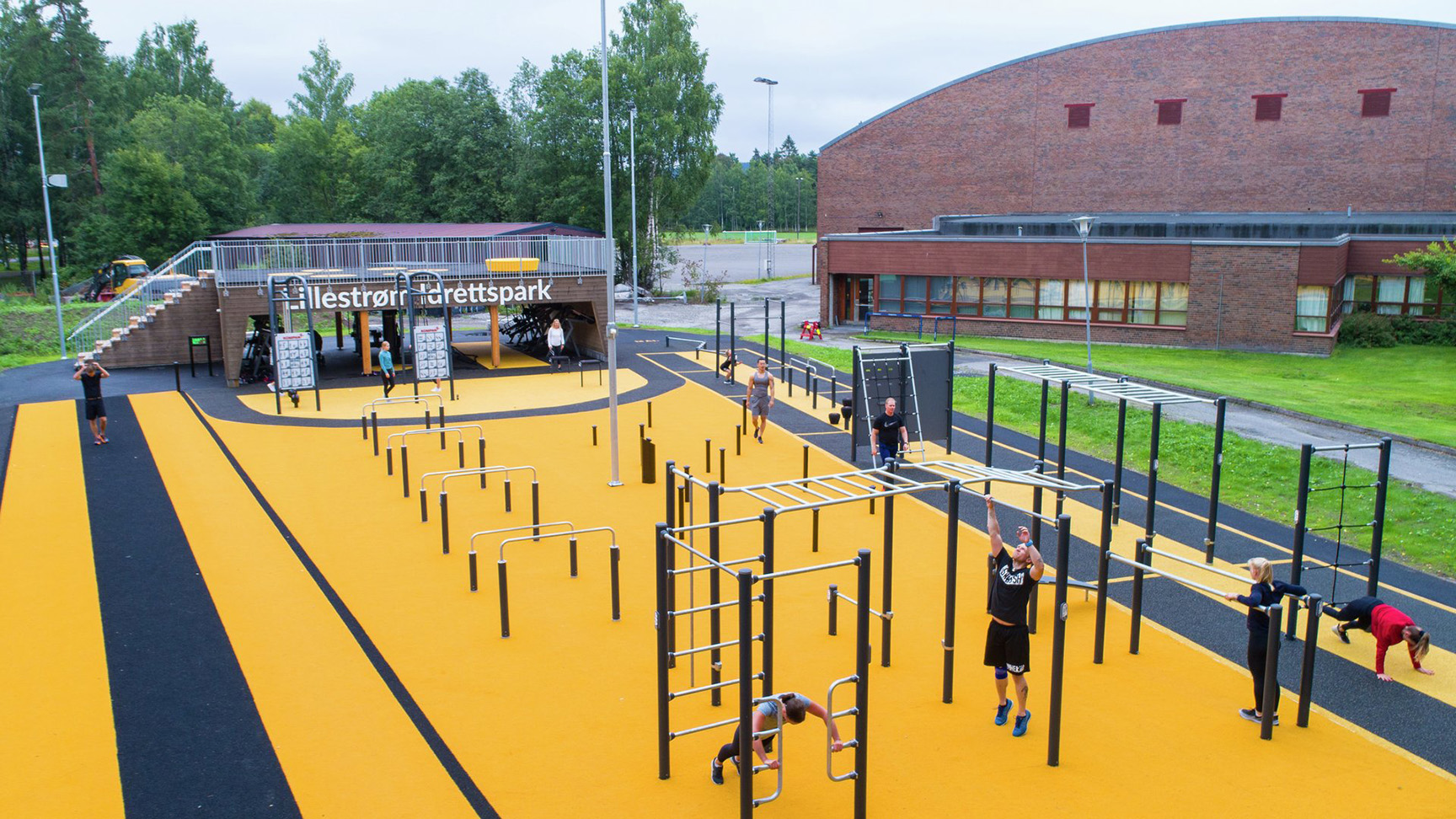 Träningspark med olika träningsredskap och träningsstationer på färgglatt underlag.