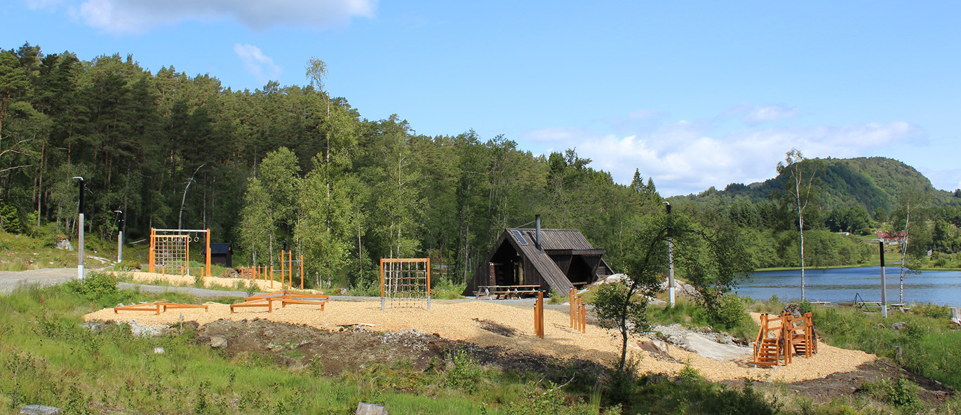 Utegym med träningsstationer av trä vackert beläget vid en sjö med utsikt.