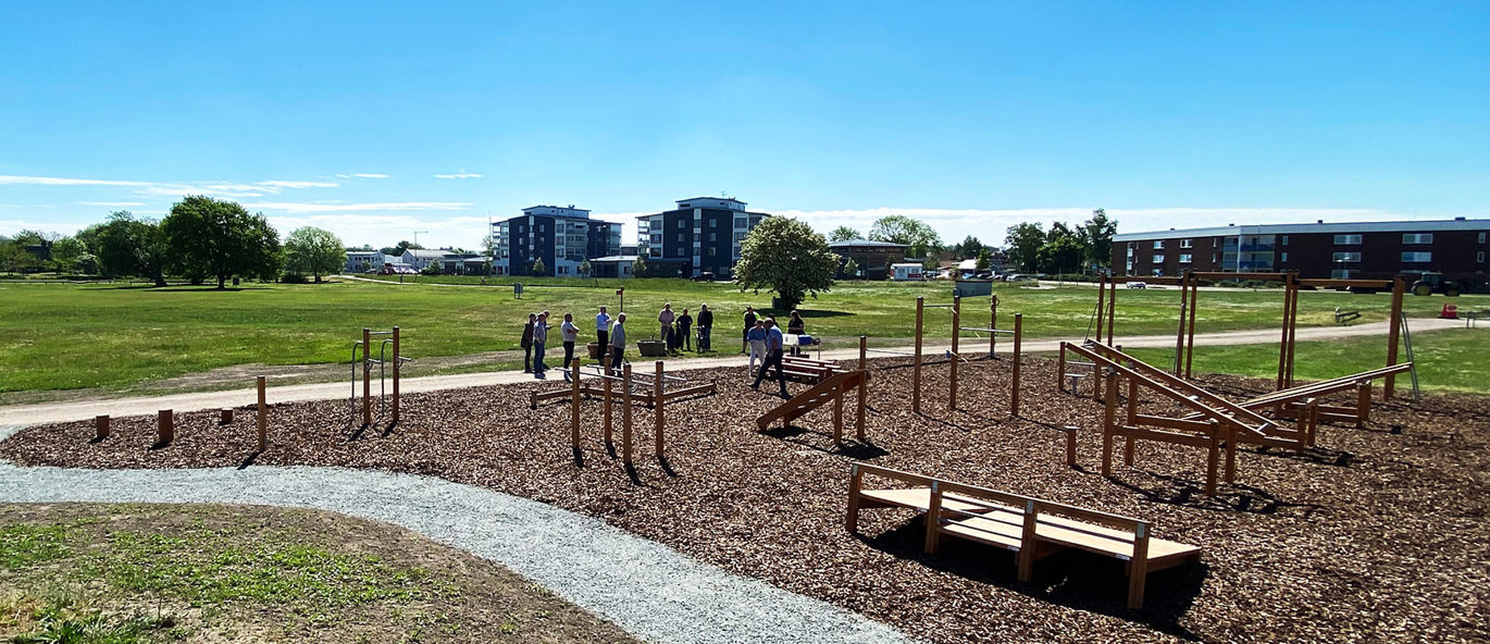 Utegym med träningsstationer av trä på en aktivitetsplats med utsikt.