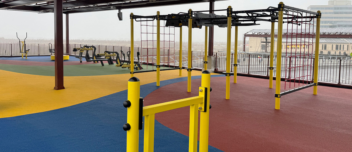 Utegymutrustning på en takterrass med färgglatt golv och utsikt.